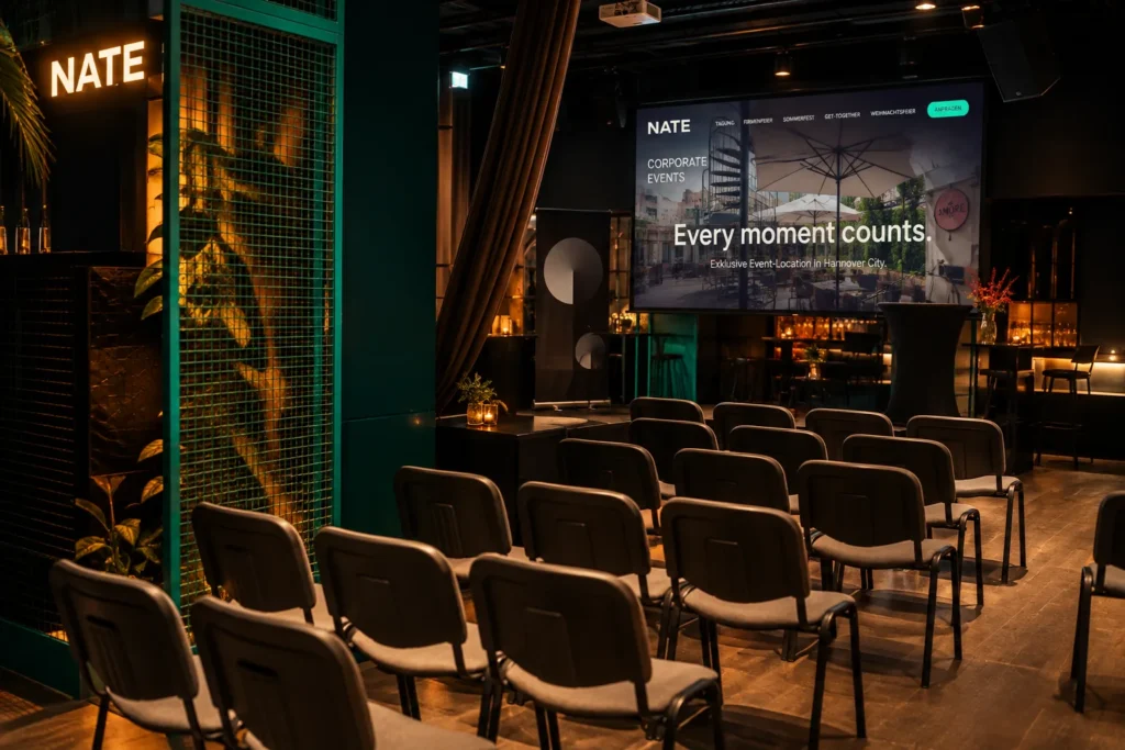 Stuhlreihen vor großer Leinwand mit Präsentation im NATE